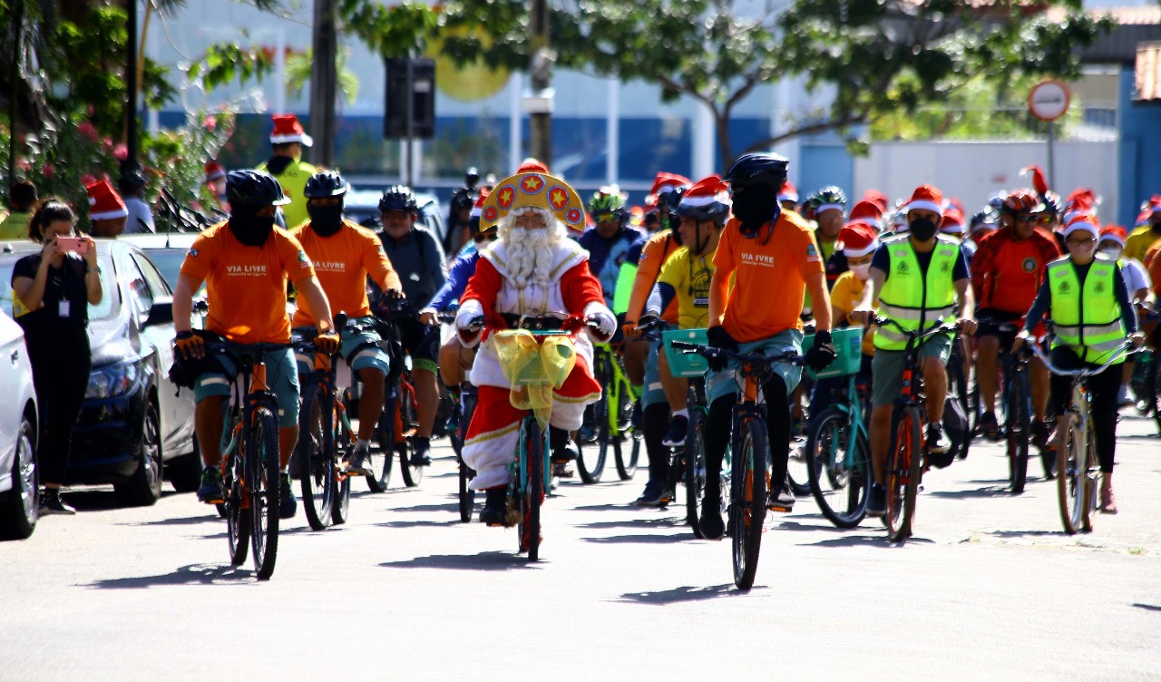 papai noel e outras pessoas andando de bicicleta